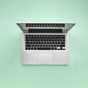 elevated-view-open-laptop-green-background-scaled.jpg